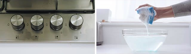 Buttons on stove in off position and hand squeezing  sponge until suds form above soapy water bowl