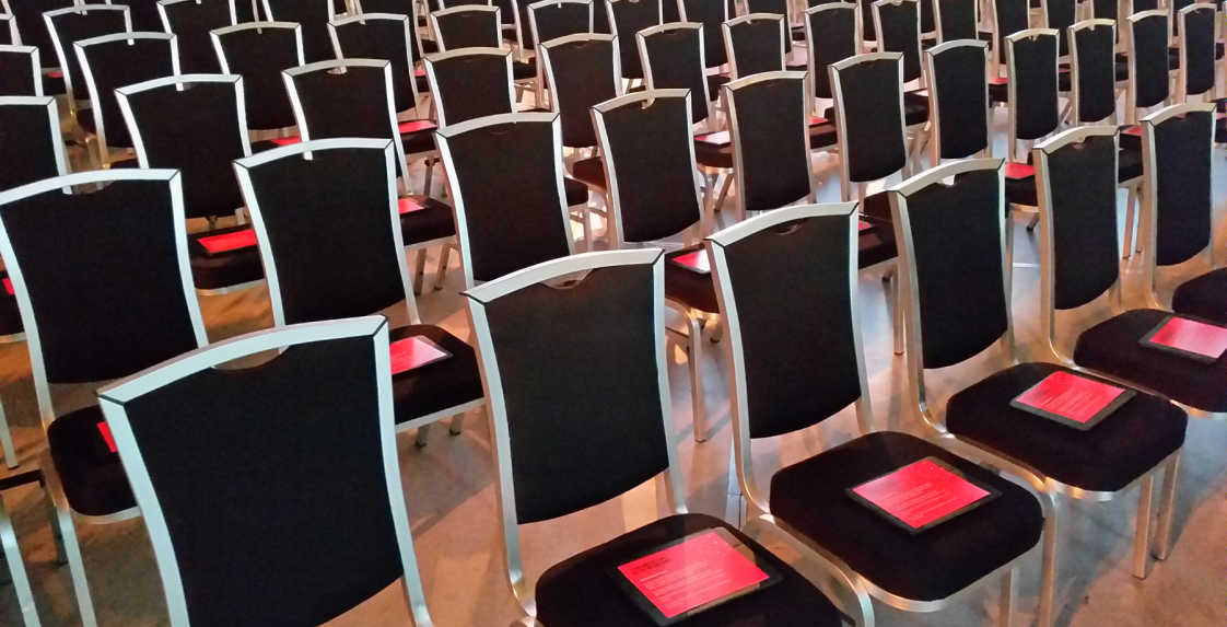 Custom Event App running on iPads neatly placed on chairs in auditorium