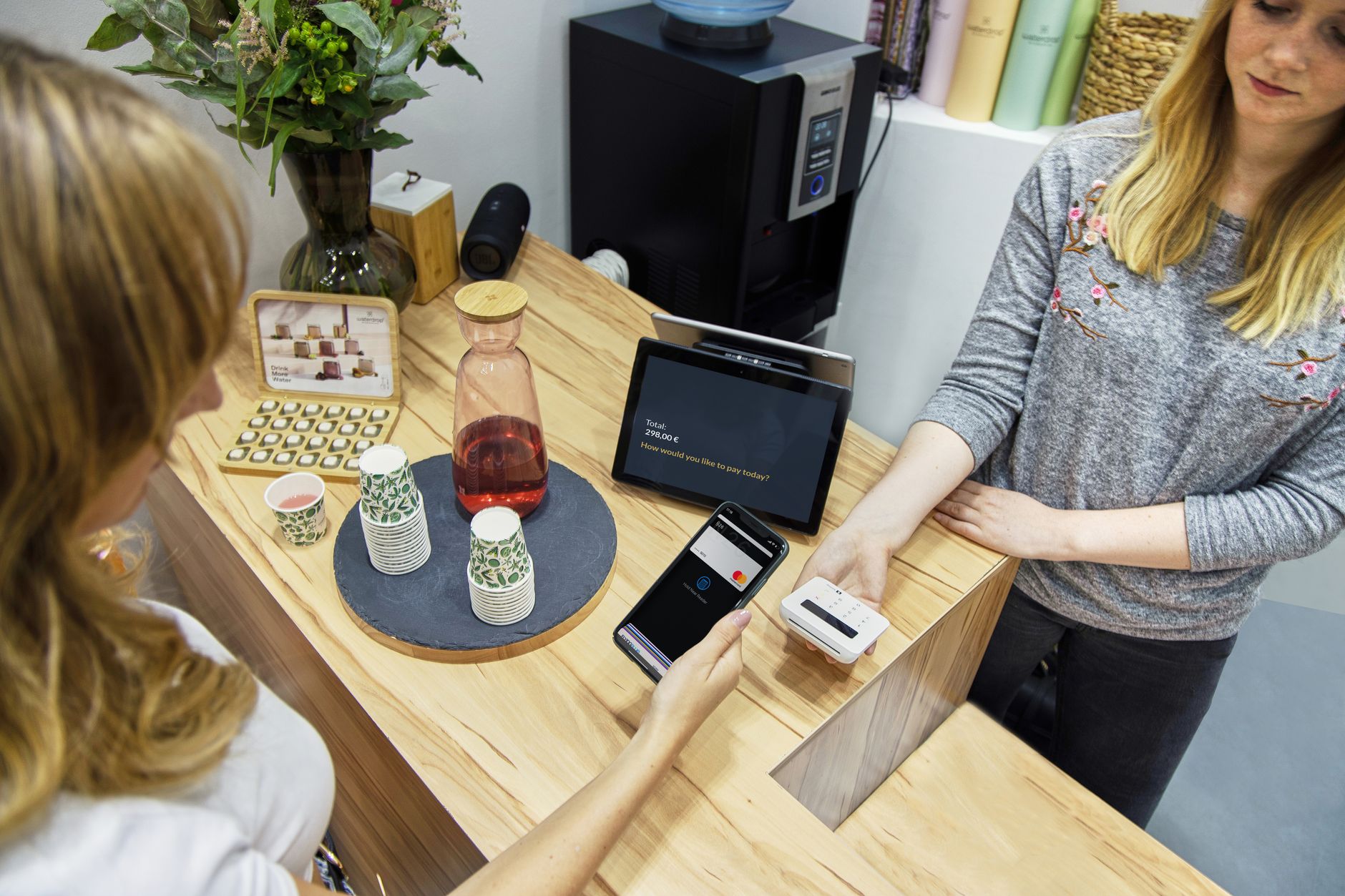 Eine Frau tätigt eine kontaktlose Zahlung in einem stilvollen Café in Berlin und hebt die Technologie und den modernen Einzelhandel hervor. · Foto: Tom Tillhub (Pexels)