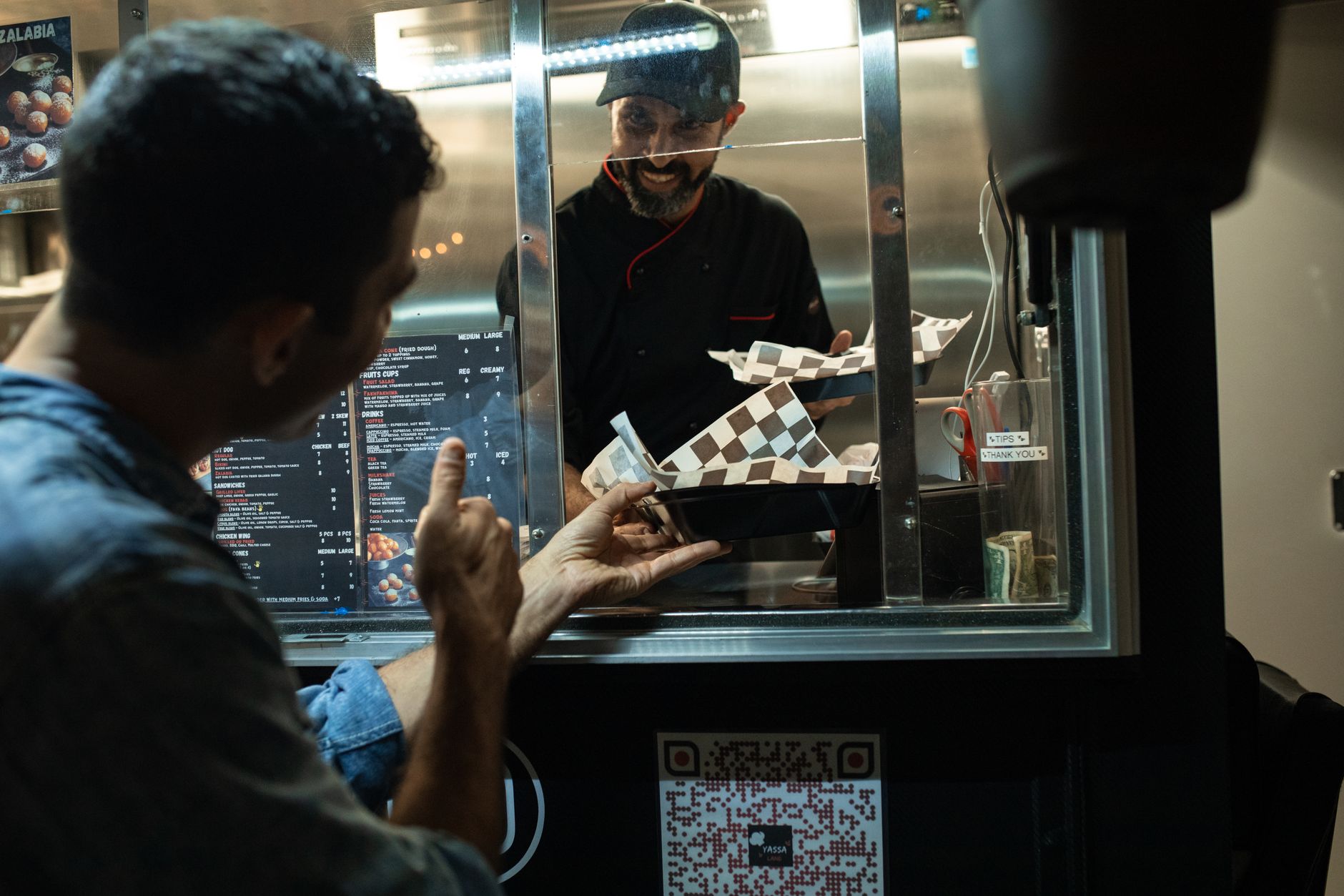 Ein Gast bestellt an einem Streetfood-Stand, während ein Mitarbeiter das Essen vorbereitet · Foto: RDNE Stock project (Pexels)