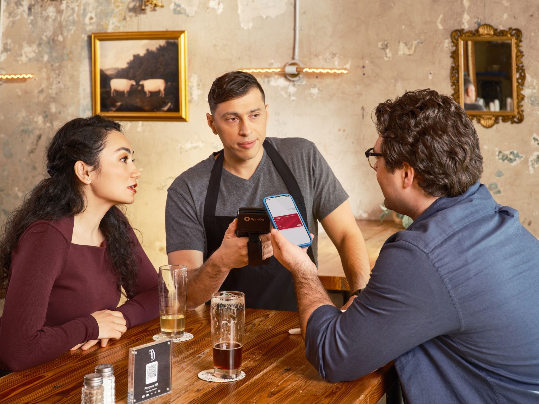 Ein Gast bezahlt kontaktlos mit dem Smartphone an einer Restauranttheke · Foto: SpotOn POS (Pexels)