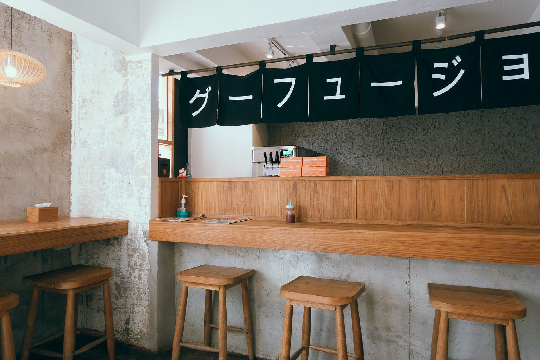 Warmer Izakaya-Innenraum mit Holzstühlen und einer schlichten Theke · Foto: Markus Winkler (Pexels)