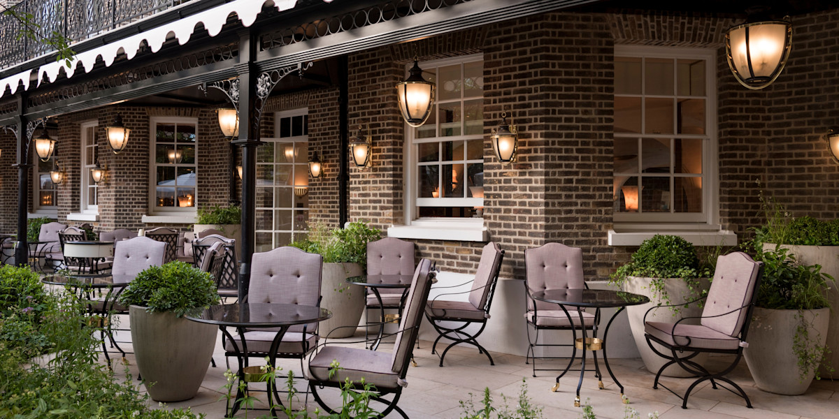 Elegant terrace seating beneath lanterns in The Ritz London’s Secret Garden