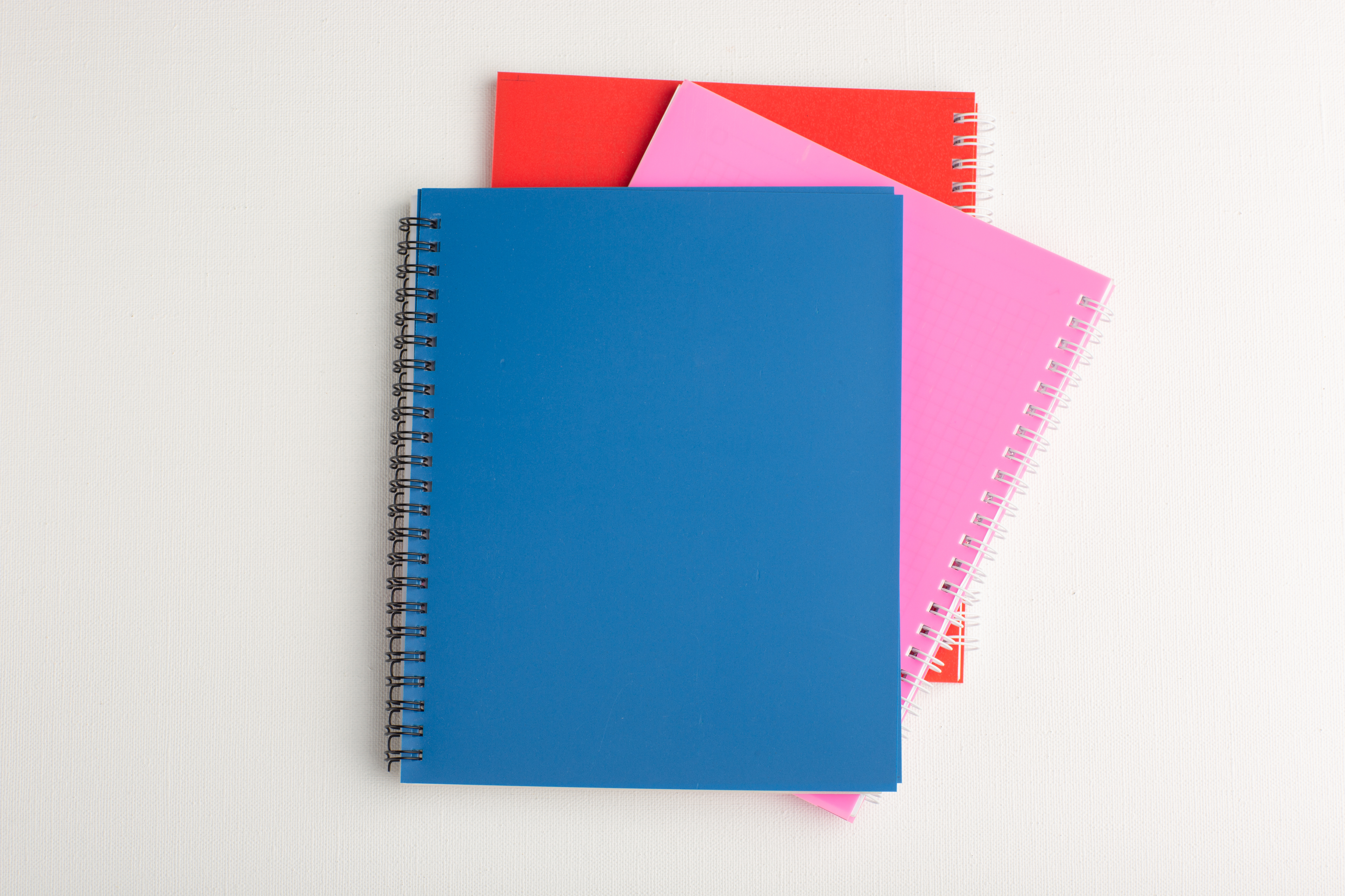 top-view-different-colorful-copybooks-white-surface