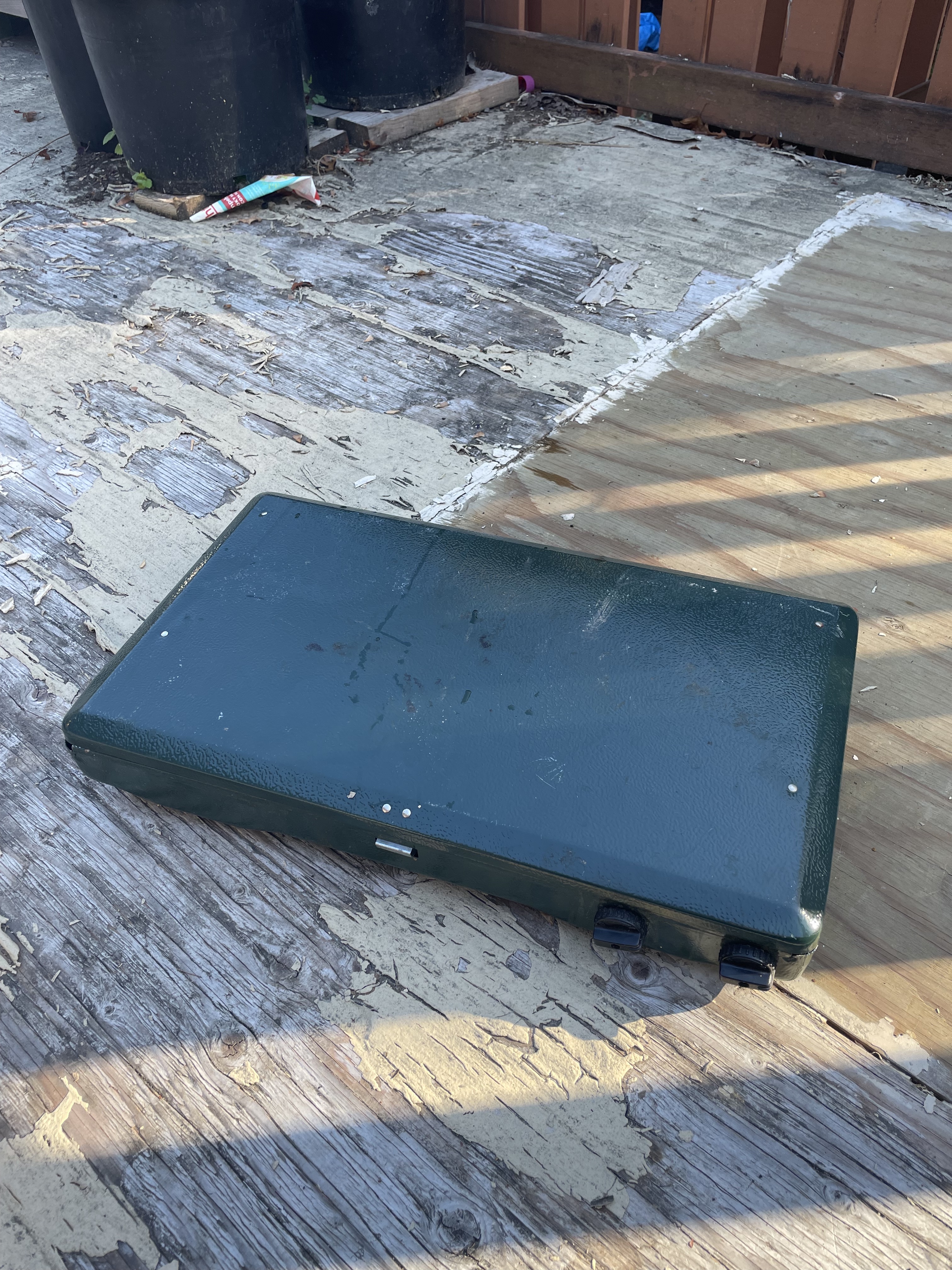 A thin rectangular heavy looking metal box for a double burner propane stove. It has no handles.