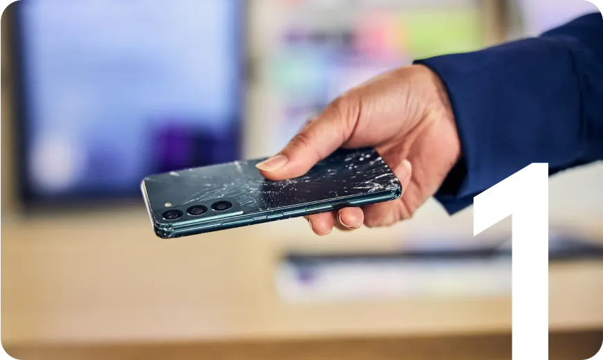 Hand holding a smartphone with a cracked back, highlighting phone repair, device trade-in, and screen damage replacement services.