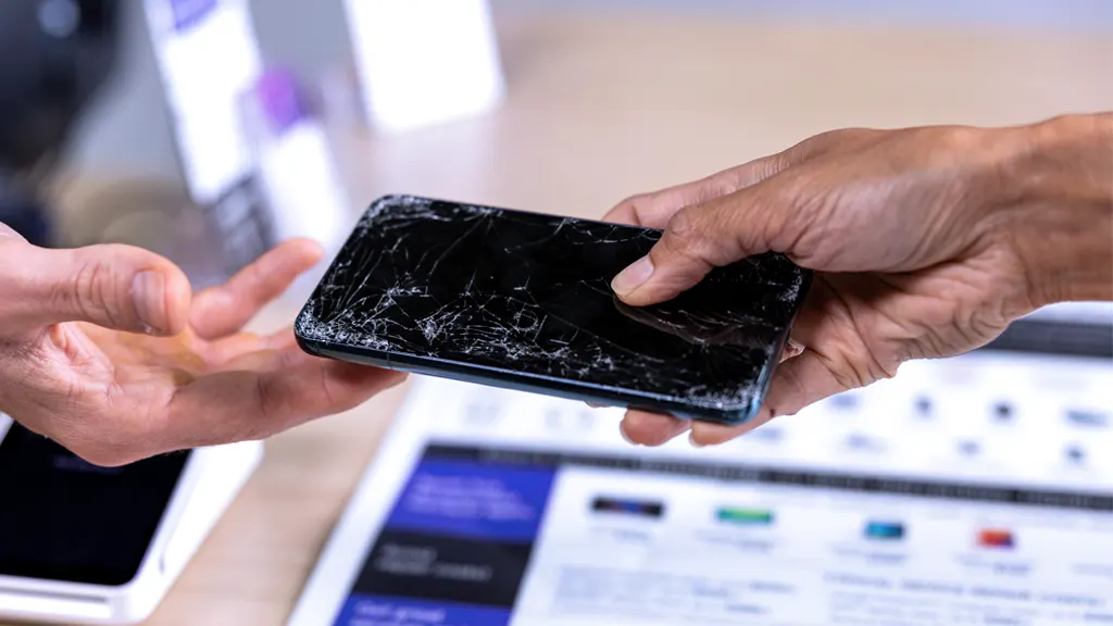uBreakiFix customer handing over dead phone to technician for data recovery services