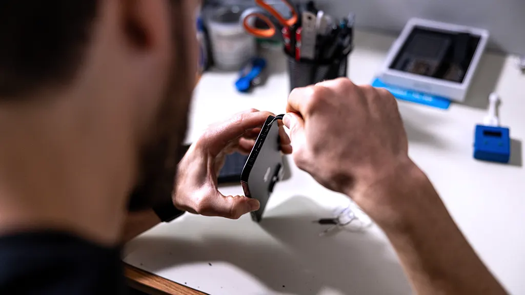 uBreakiFix repair expert in shop looking at ways to make iPhone battery last longer