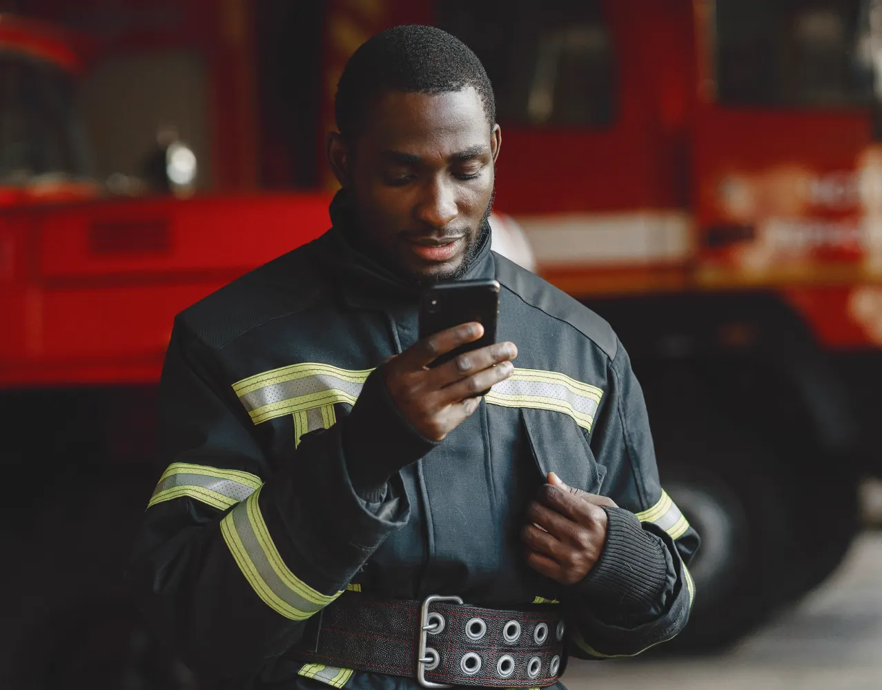 firefighter in uniform looking at his phone