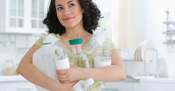 Woman holding many plastic containers in her arms