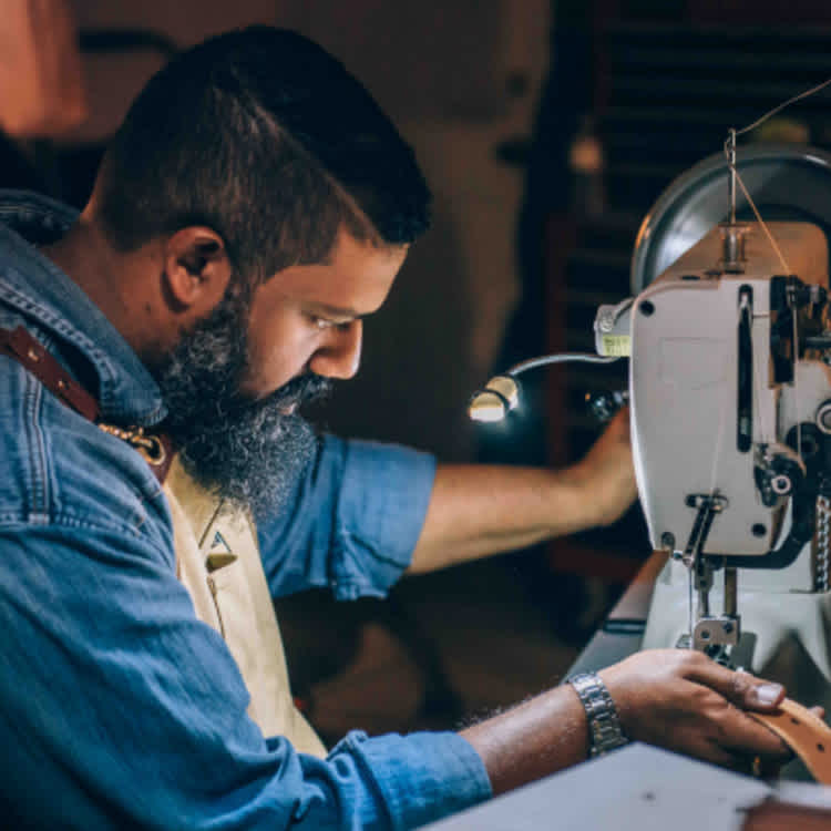 man sewing a belt