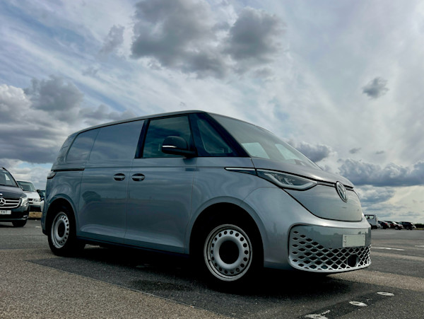 low down artistic shot looking at the front right side of the VW cargo van, with a dramatic sky in the background