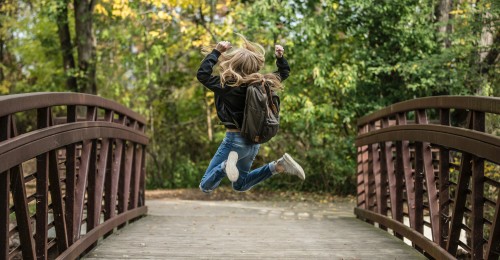 girl jumping on bridge