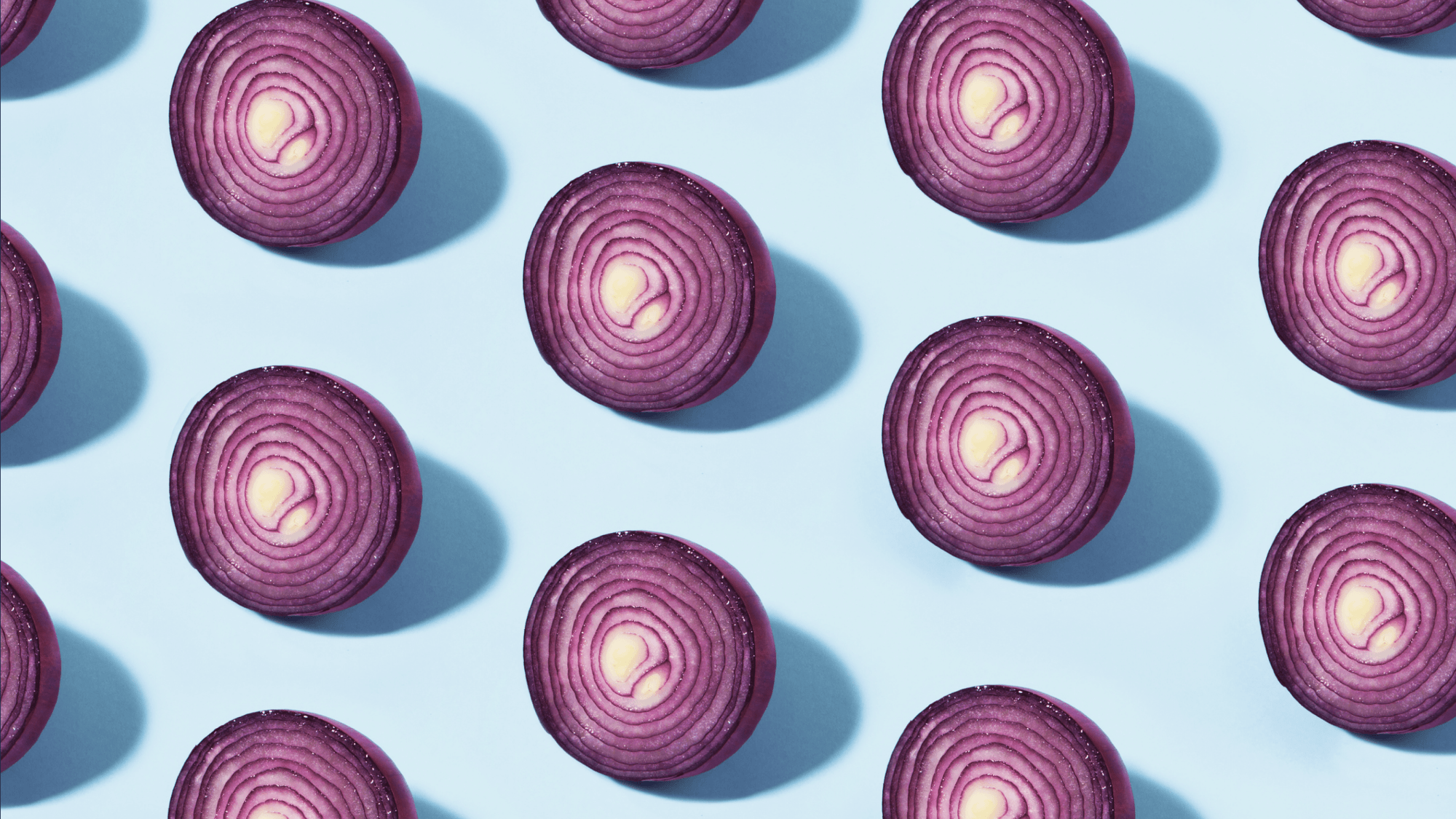 Een licht blauwe ondergrond met daarop uien. 