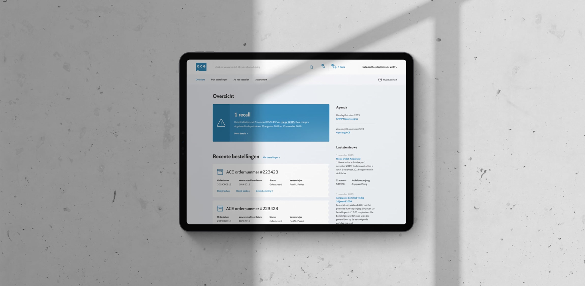 Een pagina van de Ace website staat open op een tablet die op een witte marmeren ondergrond ligt 