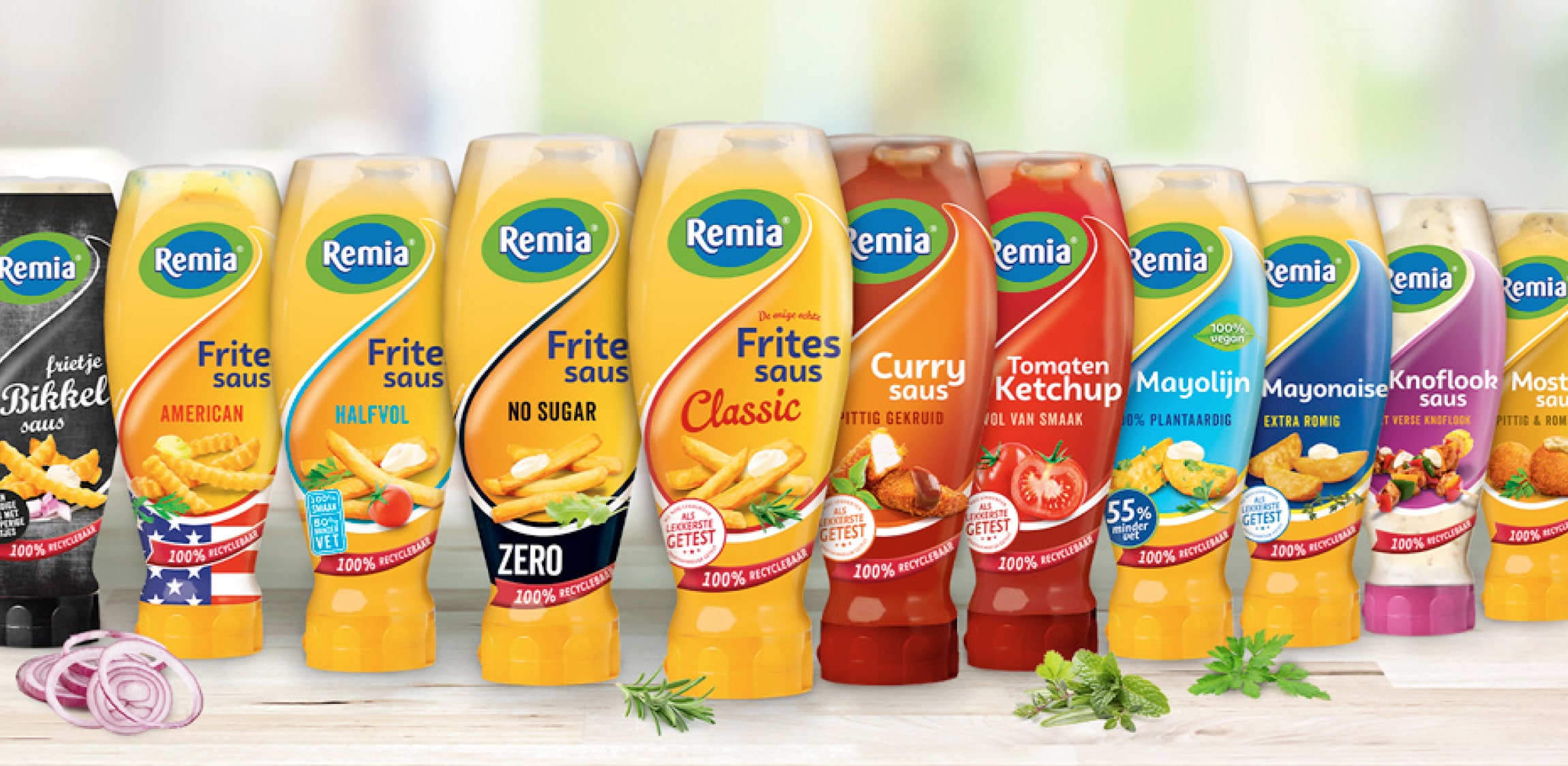 Een paar flessen saus van Remia op een rij gezet. 