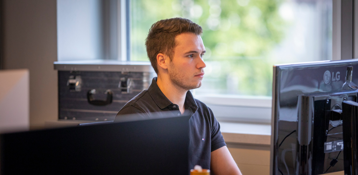 Een product owner werkt aan de planning van zijn team aan een bureau. 