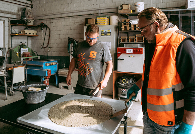 Zwei Betonlaboranten bei der Prüfung von Beton in einem Labor