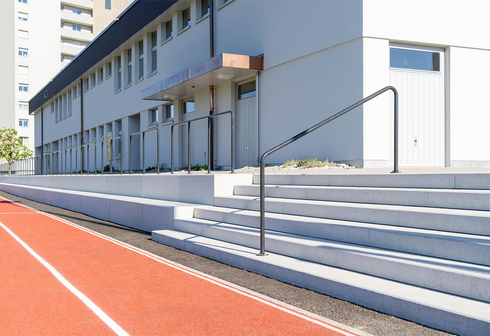 Die Vierkantelemente aus Beton dienen als Sitzgelegenheit, während die Blockstufen den einfachen Zutritt zu einer Sportanlage im Aussenbereich ermöglichen.
