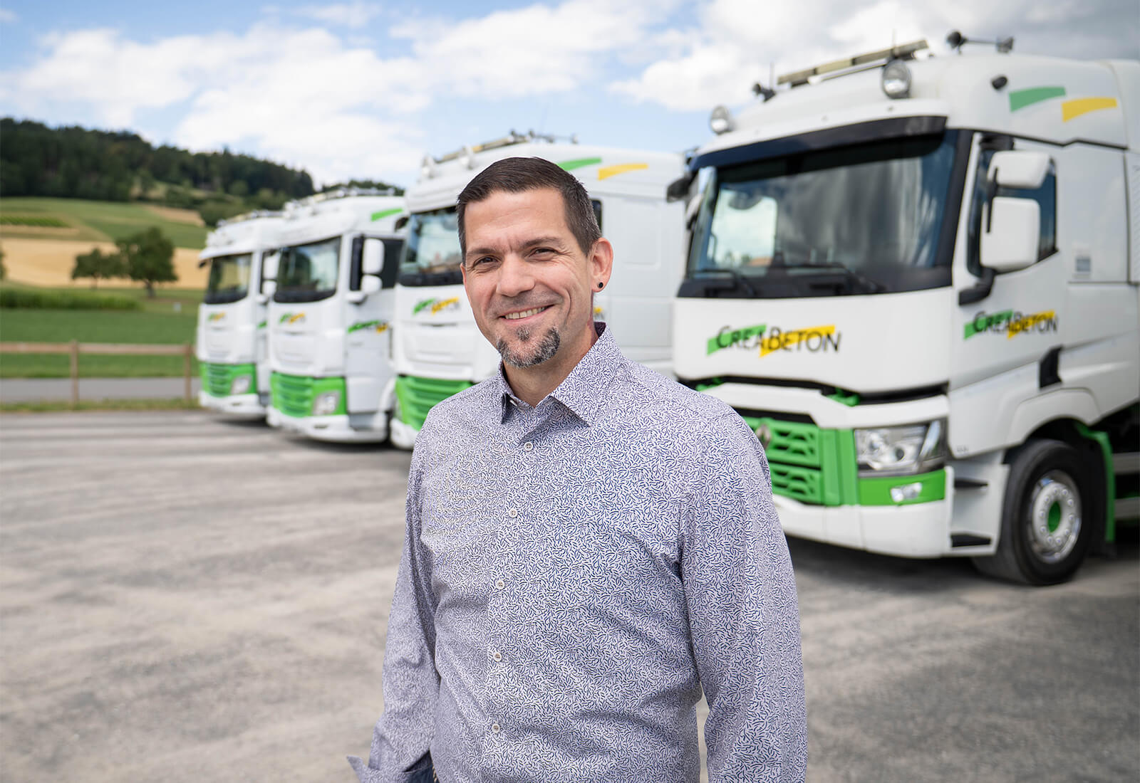 Portraitfoto von Marcel Schüpfer vor der CREABETON Transportflotte