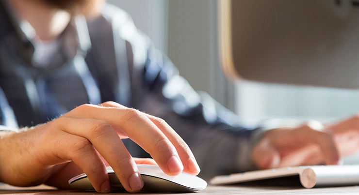 Keypad-offer-small A man holding the mouse while typing on the keyboard