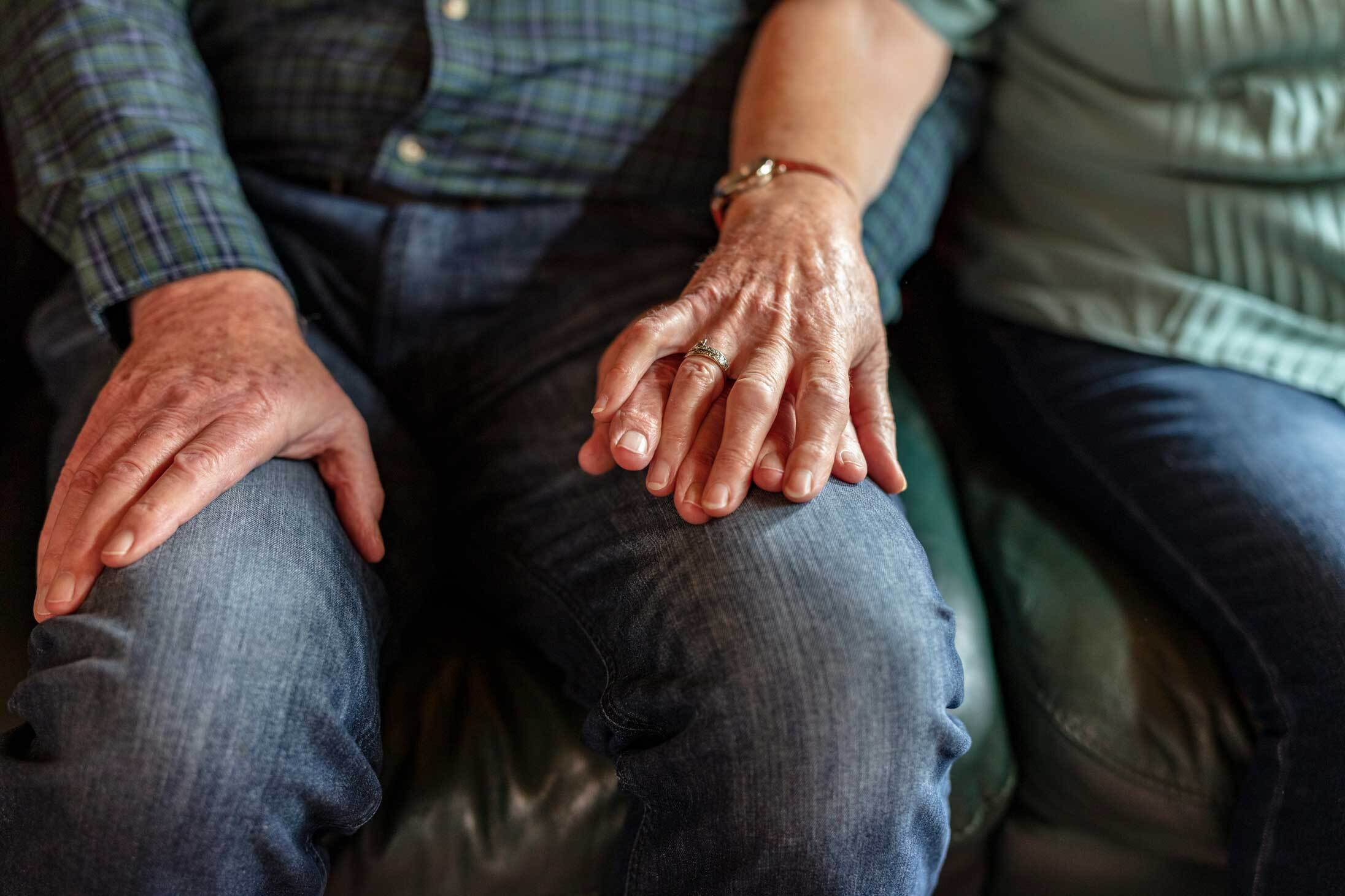 A photo of an elederly couple holding hands