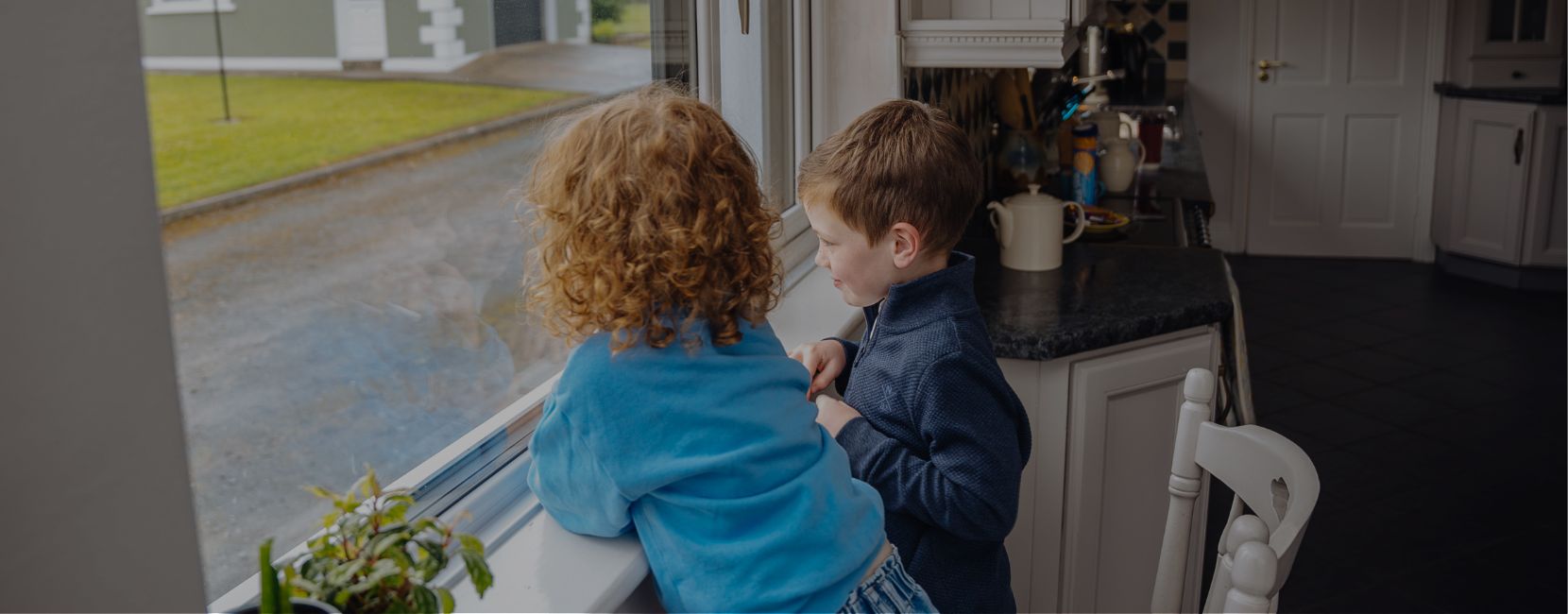 Hero Image Banner (6) Two children are staring out of a window