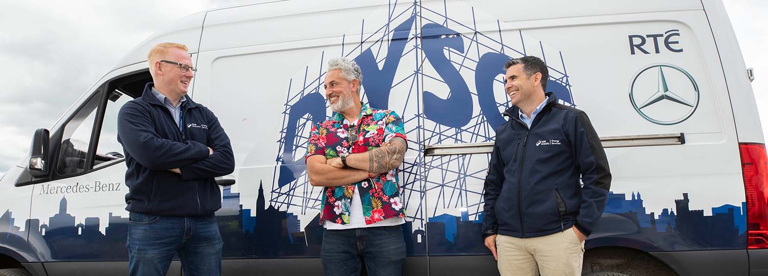 Three men by the DIY-SOS van smiling 