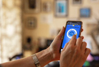 A better way to manage your energy costs A hand holding a mobile phone displaying and energy app