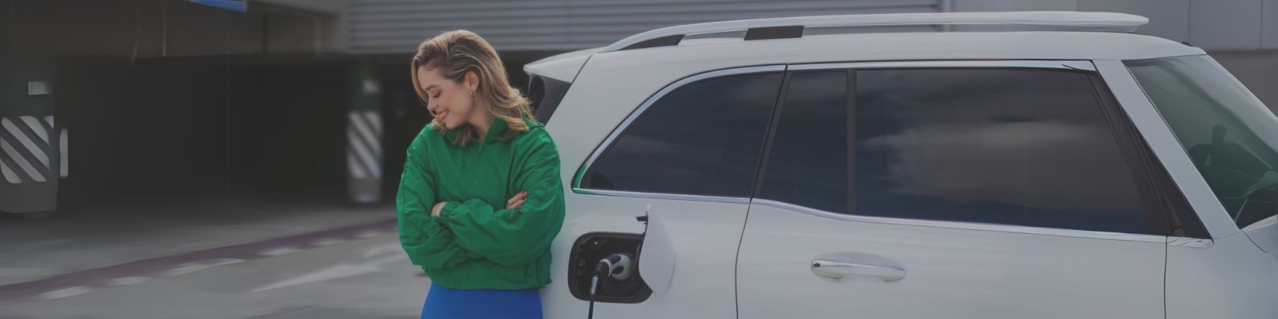 woman standing next to a charging EV