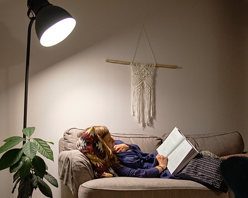 A woman reading a book on a sofa