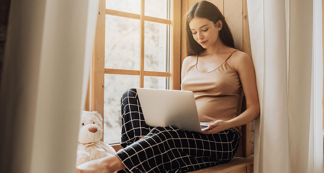 Mujer embarazada trabajando en su laptop