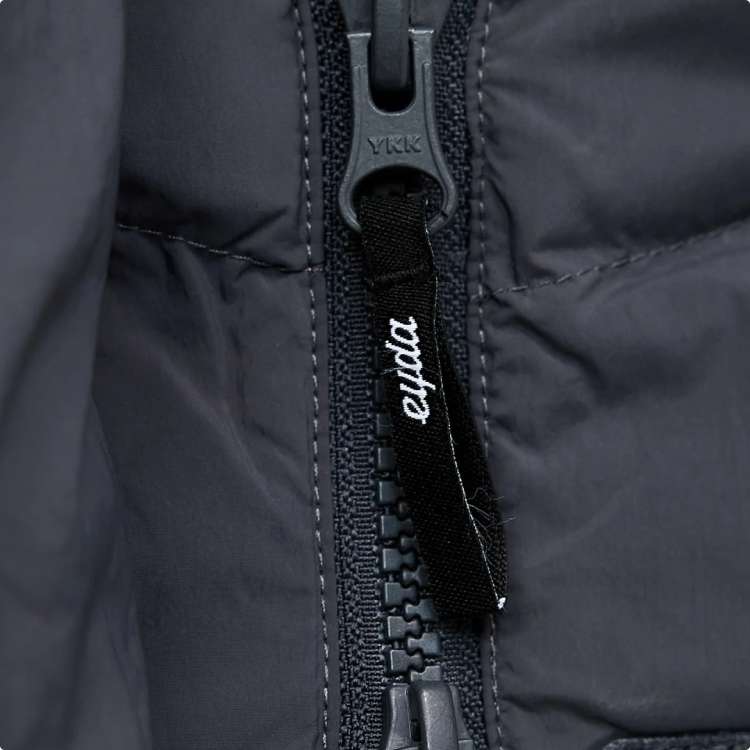 The zipper pull of a beige EYDA jacket