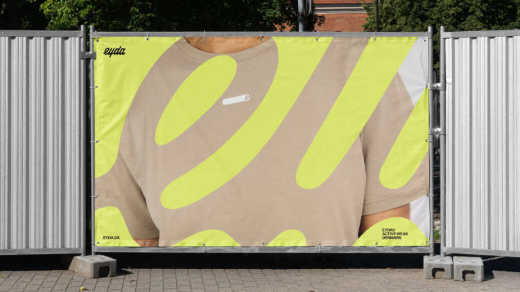 A mockup of EYDA marketing on tall temporary metal fencing