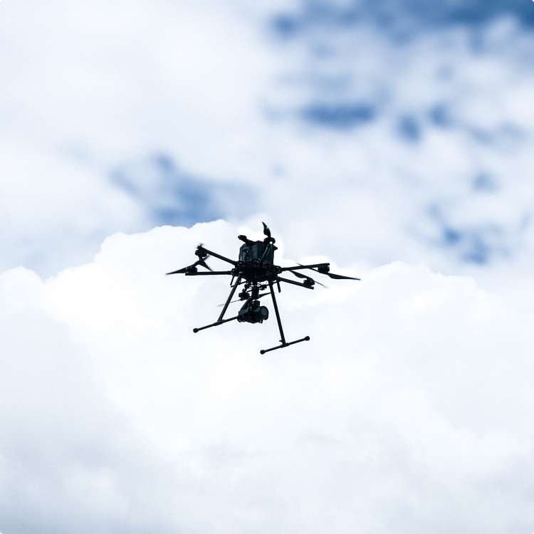 photo of a drone in flight against a cloudy sky background