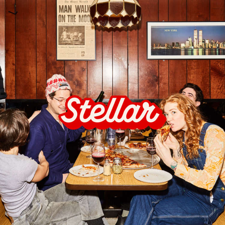A photo of people enjoying eating pizza at a table with the Stellar logo overlaid on top