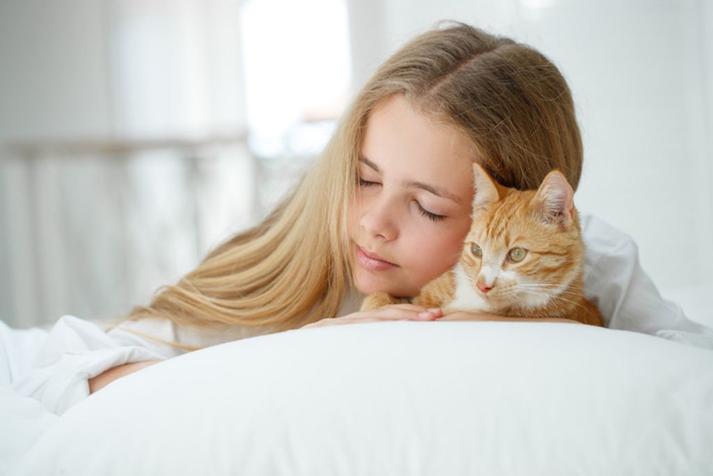 Fille avec chat sur lit