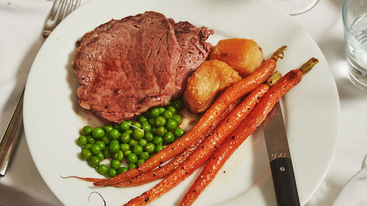 Bone-In Ribeye Roast With Roasted Carrots, Crispy Potatoes, Peas And Yorkshire Puddings