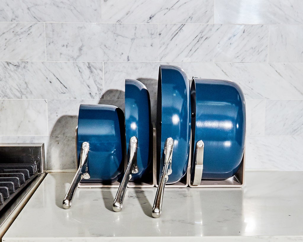 blue ceramic pots and pans stacked side by side on a counter