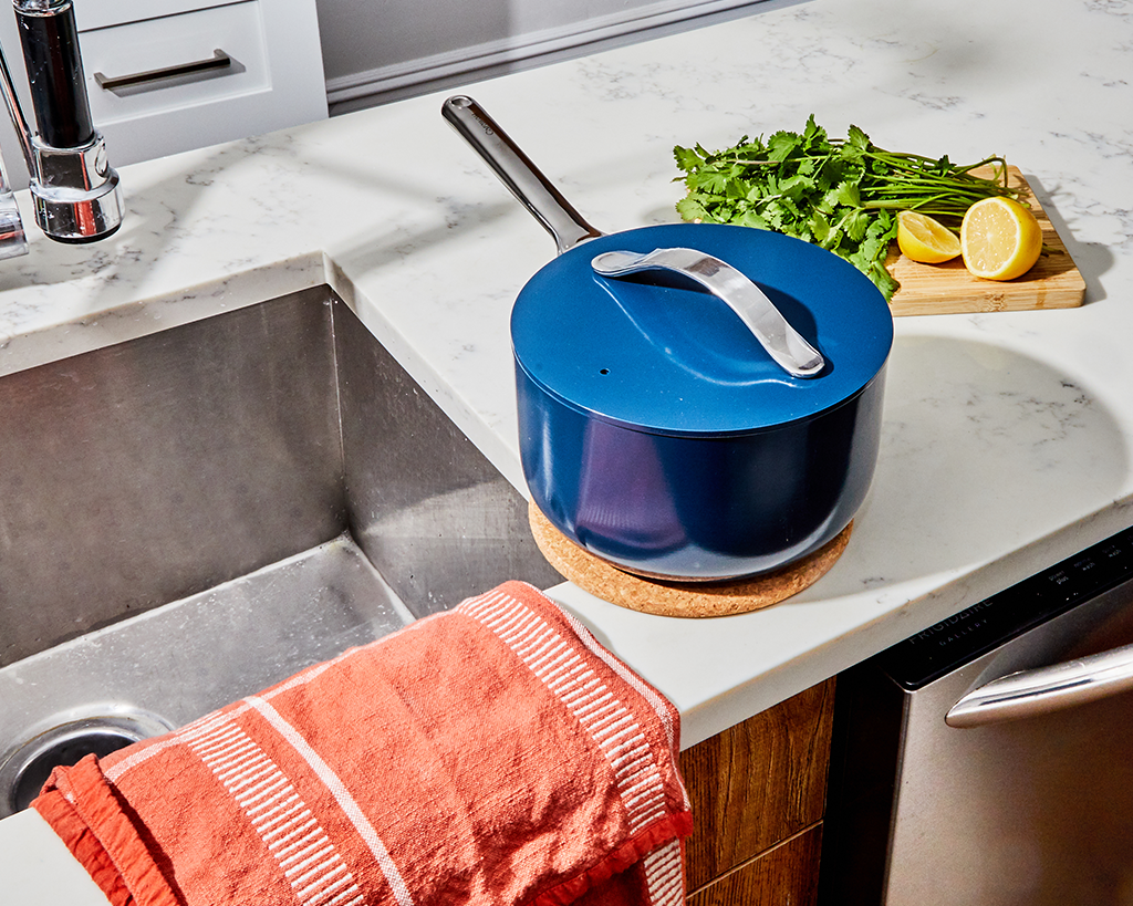 A blue ceramic Sauce Pan and a red kitchen towel