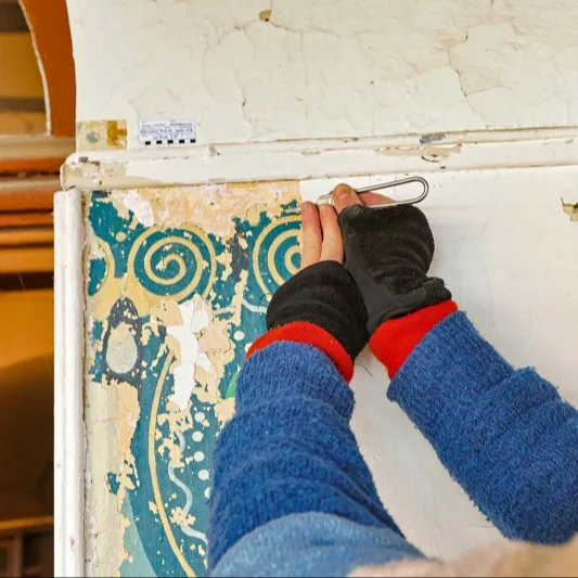 An dem Durchgang zum Eingangbereich waren Schablonenmalereien in Blaugrün- und Gelbtönen verborgen.