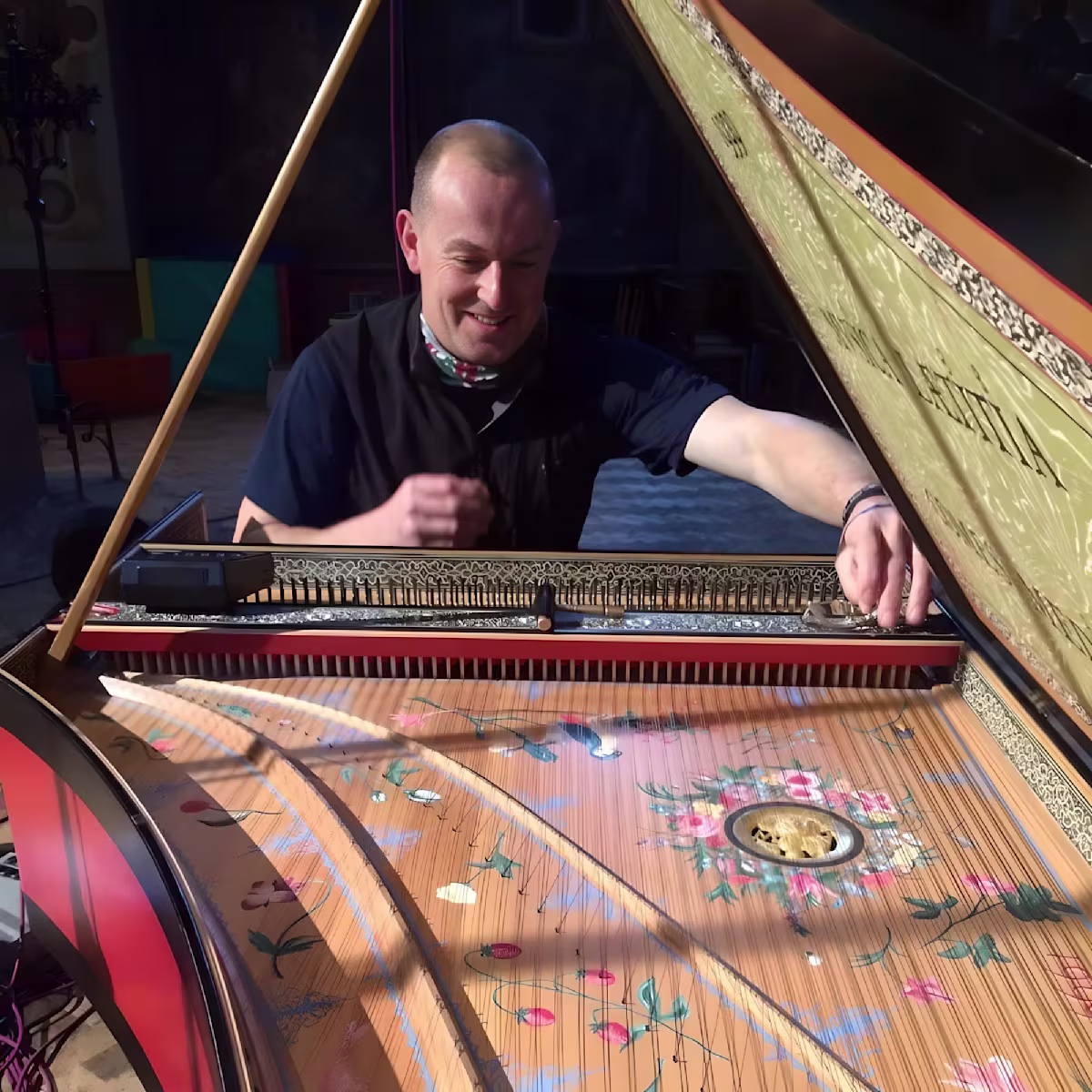 In conversation: Andrew Wooderson a man working on tuning a highly ornate harpsichord with the lid open