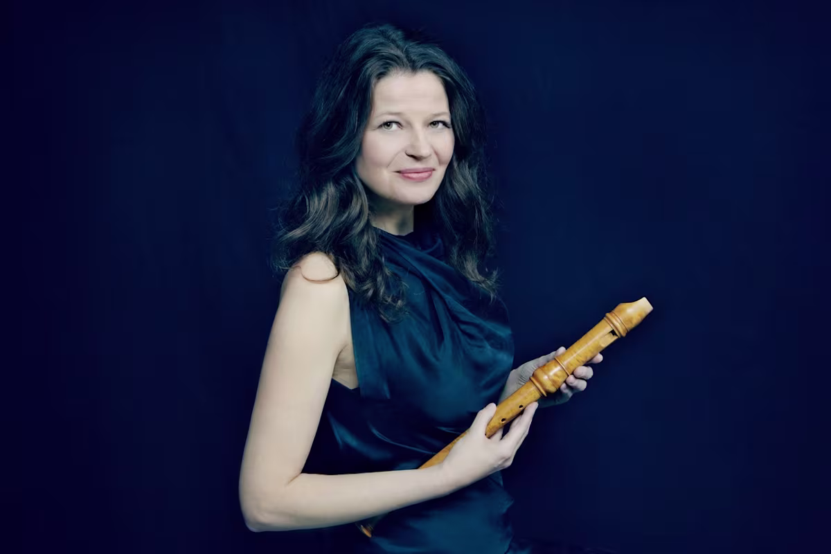 recorder player dorothee oberlinger holding a wooden recorder on a dark background