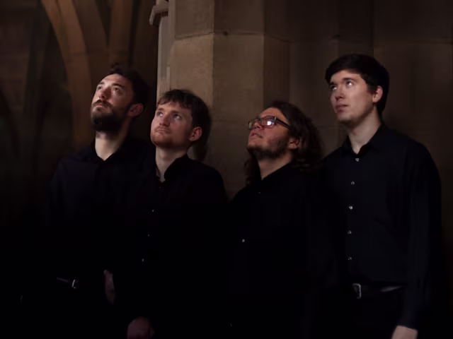 A Medieval & Modern Late-Night Encounter four members of iuchair in a church wearing all black