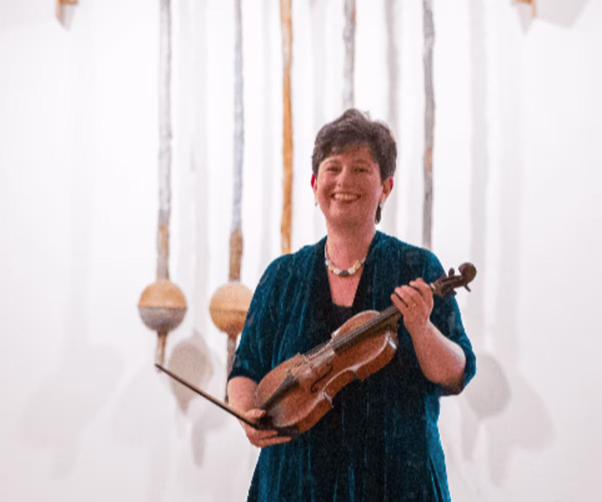 Bach and Beyond Kati Debretzeni holding her violin receiving applause at the end of a performance