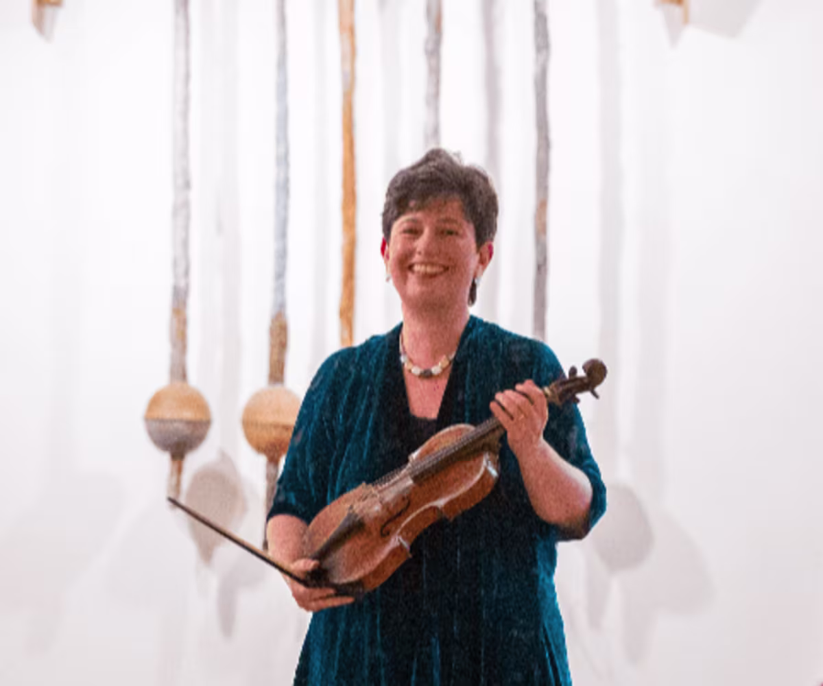 Bach and Beyond Kati Debretzeni holding her violin receiving applause at the end of a performance