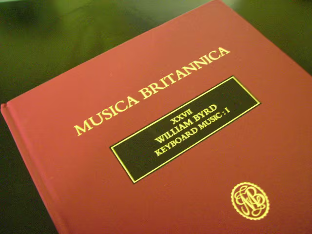 a hardback volume of keyboard music with a red colour and gold writing