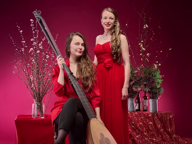Sweeter Than Roses soprano angela hicks and lutenist kristiina watt wearing red dresses with a festive background