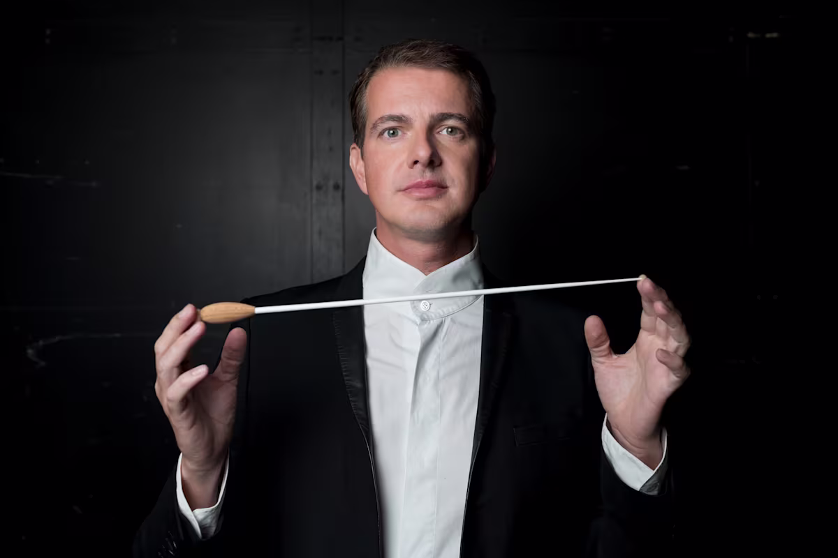 Philippe Jaroussky: Shifting spotlights from stage to score A conductor Philippe Jaroussky in a tailcoat holding a baton between his hands