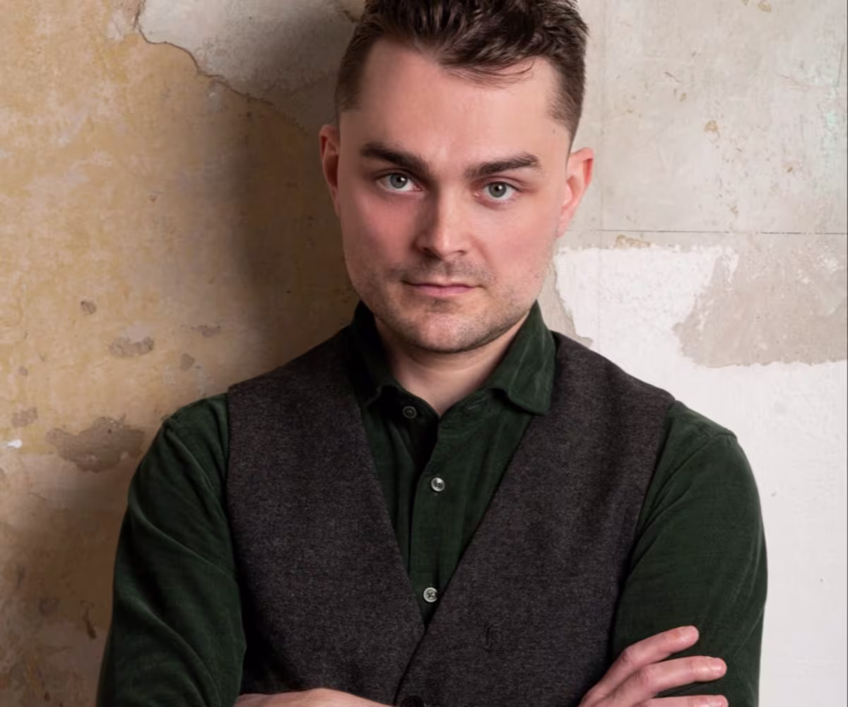 Rossini: Sacred & Profane Jakob Lehmann standing arms folded against a wall with peeling wallpaper